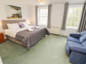 1 dormitorio con 1 cama y 1 sofá azul en The Mill, en Buxton