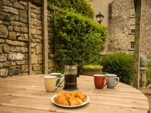 un tavolo con un piatto di croissant e tazze di caffè di The Mill a Buxton