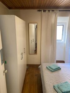 um pequeno quarto com uma cama e um espelho em Special Suite Bairro Alto em Lisboa