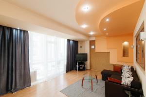 a living room with a couch and a large window at Elite Rent Anestiade in Chişinău