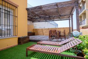 un patio con una mesa de madera y un banco de madera en Casa en Tarifa en Primera linea de Playa, en Tarifa