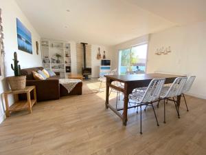 een woonkamer met een tafel en stoelen en een bank bij Maison de vacances "L'Embrun Marin" in Brem-Sur-Mer