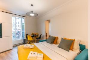 a bedroom with a large bed and a table with chairs at Magnifique apartment au coeur de Nation - 4P1BR in Paris