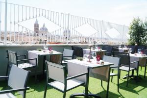 a restaurant with white tables and chairs on a roof at Best Western Plus Hotel Universo in Rome