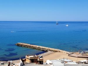 vistas a una playa con un muelle en el agua en Hotel Admeto, en Marinella di Selinunte