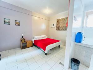 una camera con letto rosso e doccia di The Cabin byTERBAIKhome a Città di Puerto Princesa