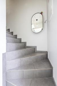 a stairway with a mirror and a circular mirror at Apartamentai Čiki puki 2 aukštas in Palanga +16 photos