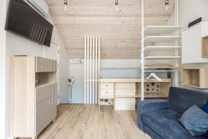 a living room with a blue couch and a bunk bed at Apartamentai Čiki puki 2 aukštas in Palanga
