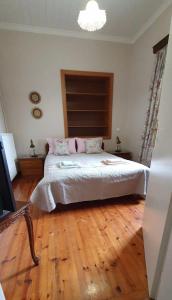 um quarto com uma cama grande e piso em madeira em Best House, Green Home, Elaiofyto Village, Agrinio, Aitoloakarnania 