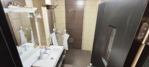 La salle de bains est pourvue d'un lavabo et d'un miroir. dans l'établissement Guest house, à Târgu Jiu