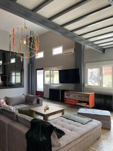 a living room with a couch and a tv at Πανέμορφο design,ηλιόλουστη ισόγεια μεζονέτα in Kastoria