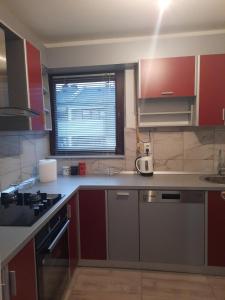 a kitchen with red cabinets and a stove top oven at Džoni in Sarajevo