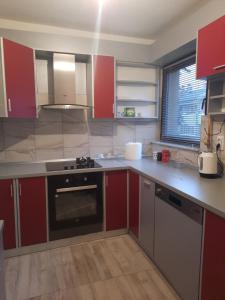 a kitchen with red cabinets and a stove top oven at Džoni in Sarajevo