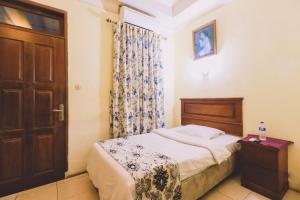 um quarto com uma cama e uma porta de madeira em PIA Hotel Medan em Medan