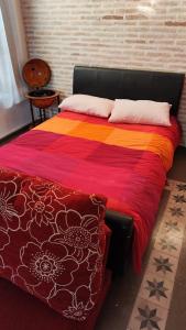 a bedroom with a bed with a colorful blanket at rincones con encanto 