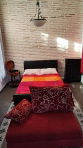 a bedroom with a bed with a red blanket and pillows at rincones con encanto 