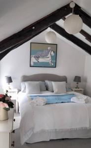 een slaapkamer met een wit bed in een kamer bij The Flower House, Idyllic Cornish Retreat. in Saint Erth