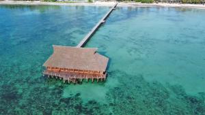 an island in the water with a building in it at Pongwe Bay Resort in Pongwe