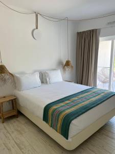 ein Schlafzimmer mit einem Bett mit einer bunten Decke darauf in der Unterkunft À Espera - Turismo Rural,Melides in Melides