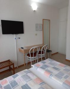 a bedroom with a desk and a bed and a table at Apartments & Rooms Karmen in Portorož