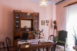 a dining room with a table with a laptop on it at Bed & Breakfast La Casa Antica in Macomer