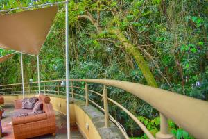a chair sitting on a porch in front of a tree at Ufanisi Resort - Kisii in Kisii