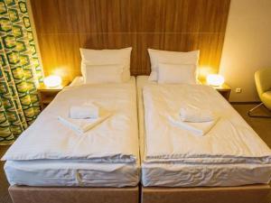 a bedroom with two beds with white sheets at Hotel Na Šustně in Krupá