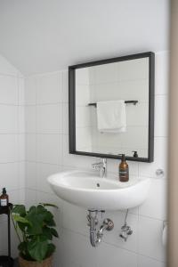 La salle de bains est pourvue d'un lavabo blanc et d'un miroir. dans l'établissement Exklusive Stadtoase mit Panoramablick nähe Hauptbahnhof, à Coblence