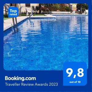 a blue swimming pool with a sign that reads top rated traveller review awards at Casa Palma in Los Alcázares