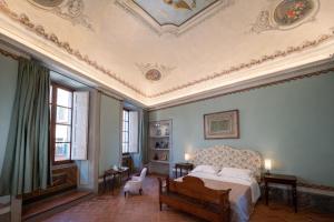 1 dormitorio con cama y techo artesonado en Delcorto Suites en Montepulciano