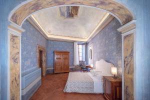 una camera da letto con pareti blu, un letto e un arco di Delcorto Suites a Montepulciano