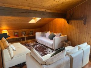 una sala de estar con 2 sofás blancos en un ático en Mansarda con vista sul Monte Rosa en Champoluc