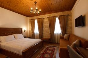 a bedroom with a bed and a couch at Rose Garden Hotel in Gjirokastër