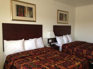 Postel nebo postele na pokoji v ubytování America Inn & Suites