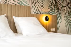 a bedroom with two beds with white pillows at O'Cub Hotel in Villeneuve-lès-Avignon