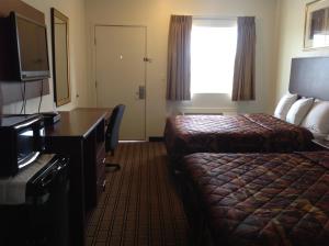 Postel nebo postele na pokoji v ubytování America Inn & Suites