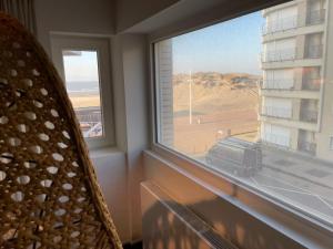 a room with a window with a view of a building at Vista del Mar Japandi in Koksijde