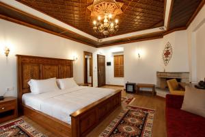 1 dormitorio con 1 cama y sala de estar en Rose Garden Hotel en Gjirokastër