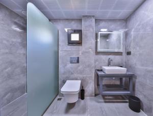 a bathroom with a toilet and a sink at White House Apart in Kaş