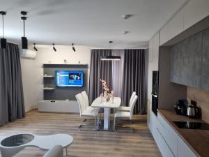 a kitchen and dining room with a white table and chairs at Dariq in Kazanlŭk