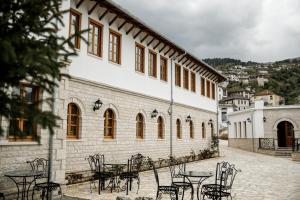 a group of tables and chairs in front of a building at Rose Garden Hotel in Gjirokastër