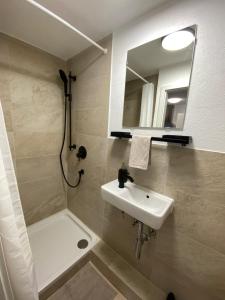 a bathroom with a sink and a mirror and a shower at Gemütliches Apartment am Waldrand in Haiterbach