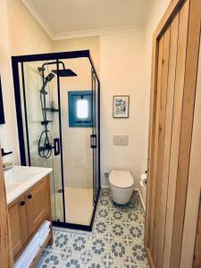 a bathroom with a shower and a toilet and a sink at Jakaranda Unique Apart in Bodrum City