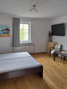 a bedroom with a bed and a flat screen tv at Krasiczyn nocleg in Krasiczyn