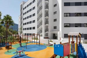 a playground in front of a building at Brand new apartment with pool and SEA VIEW in Marbella in Marbella