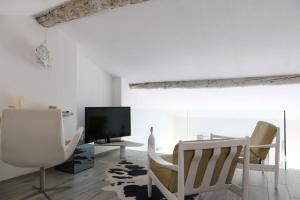 ein Wohnzimmer mit 2 Stühlen und einem TV in der Unterkunft Le Coccinelle Home a Lierna in Lierna