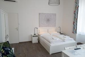 ウィーンにあるVienna4you 14 you are welcomeの白いベッドルーム(ベッド1台、ランプ2つ付)