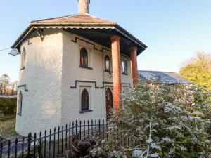 an old house with a chimney and a fence at Llwyngwair Lodge in Newport Pembrokeshire