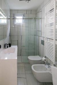 ein Bad mit einem Waschbecken, einem WC und einer Dusche in der Unterkunft Le Coccinelle Home a Lierna in Lierna