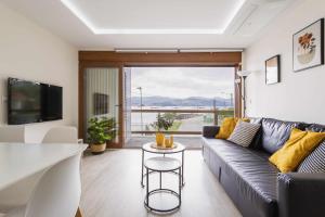 een woonkamer met een bank en een tafel bij El balcón de Covelo in Pontevedra